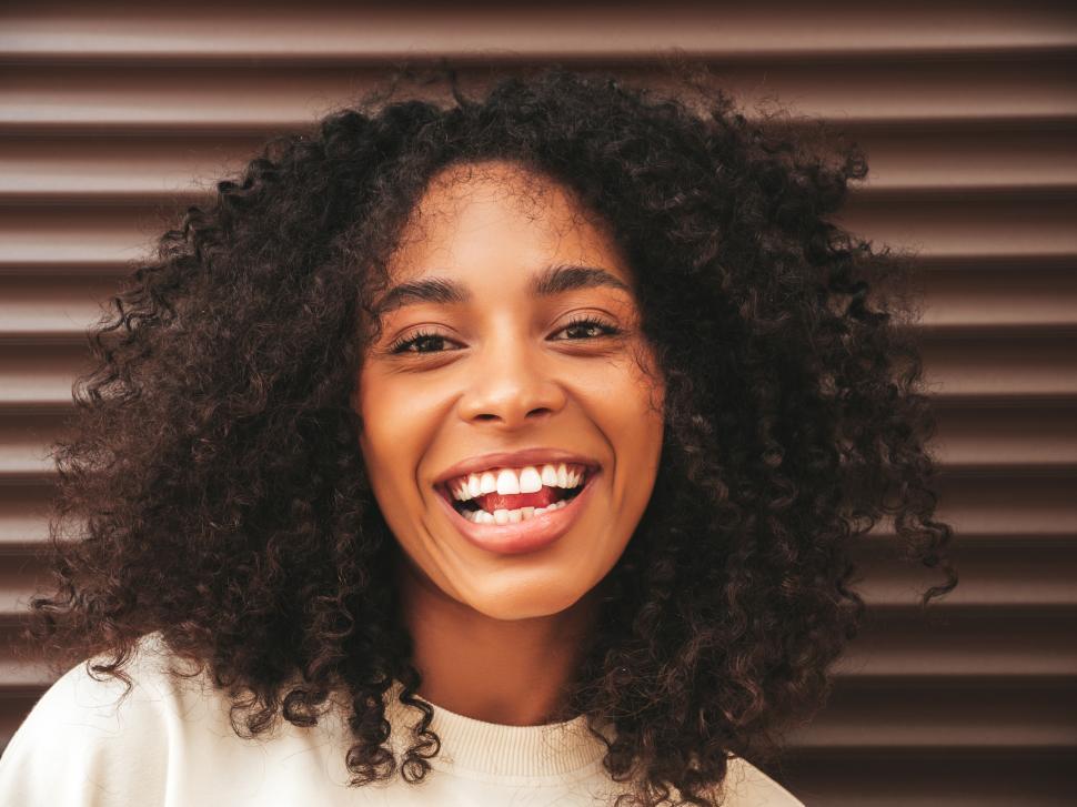 Free Image of A woman smiling with curly hair 