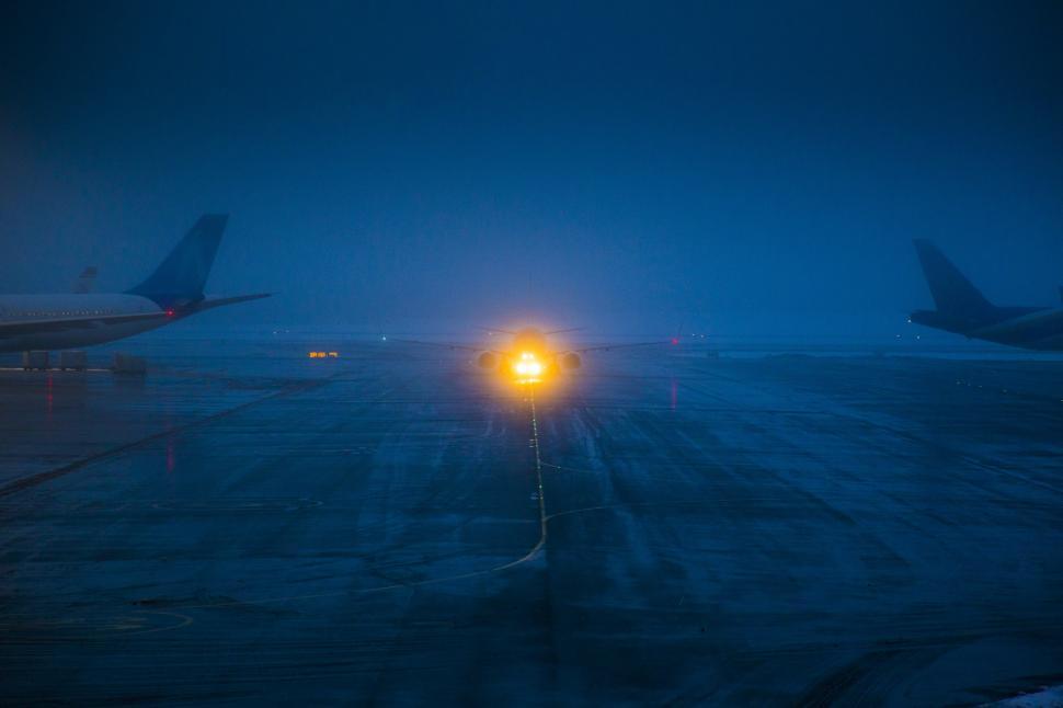 Free Image of An airplane on a runway at night 
