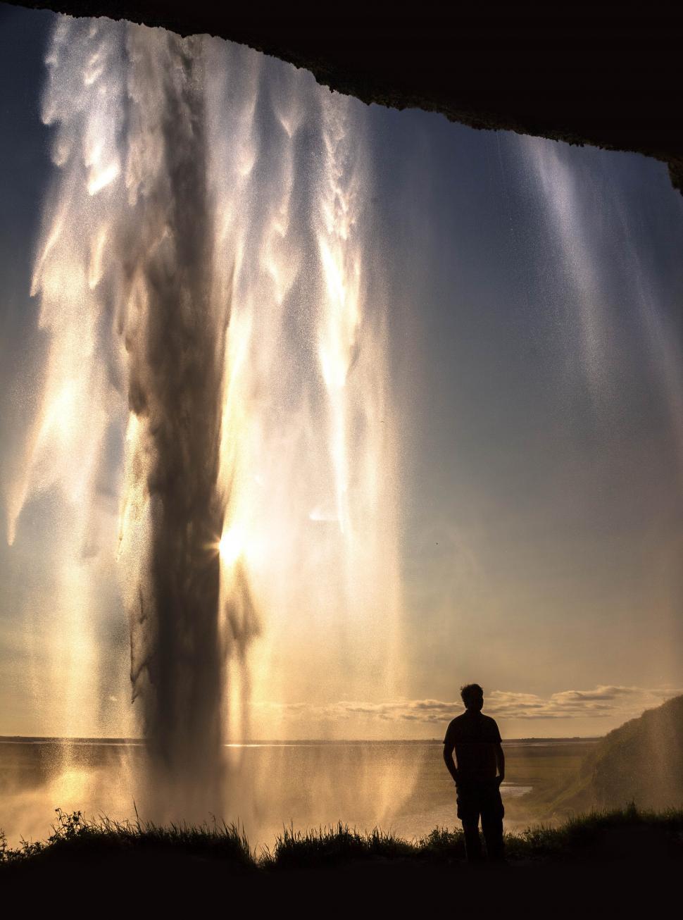 Free Image of A man standing in front of a geyser 
