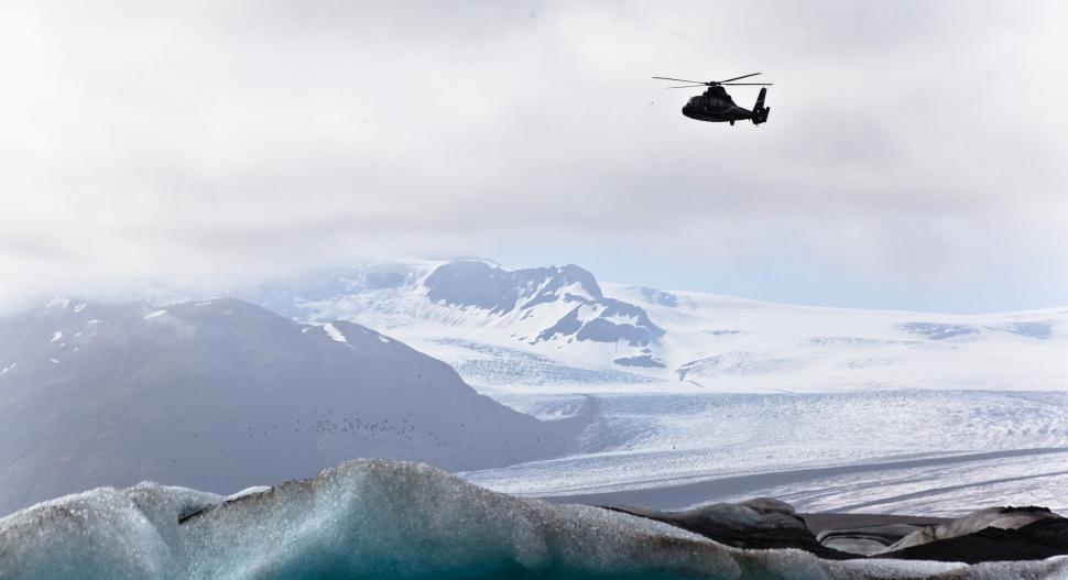 Free Image of A helicopter flying over a snowy landscape 