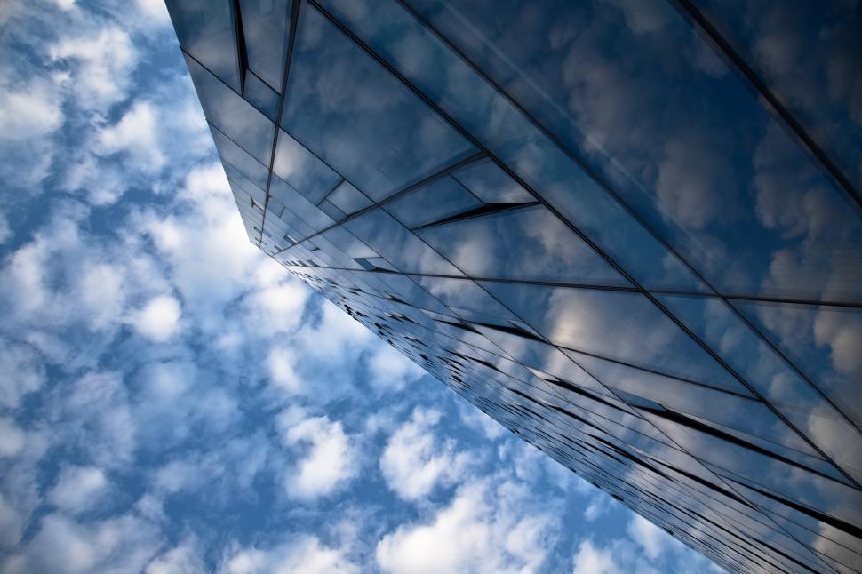 Free Image of A glass building with clouds in the sky 