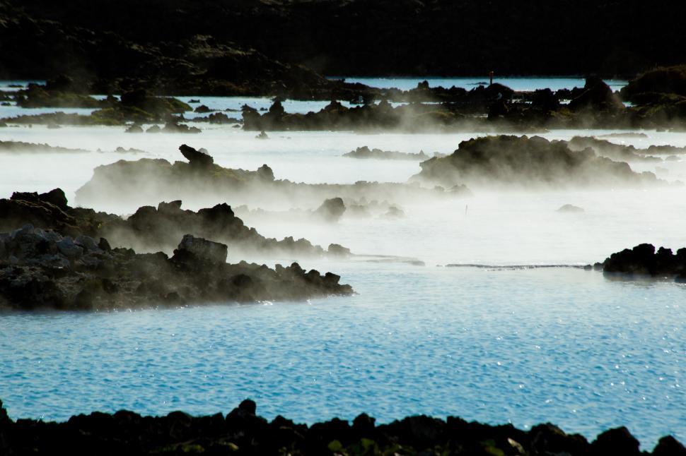 Free Image of A body of water with rocks and steam 