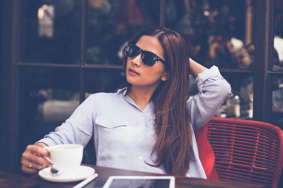 Free Image of Woman at cafe wearing sunglasses 