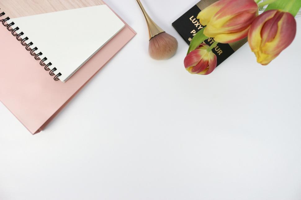 Free Image of Beauty essentials with tulips on a desk 
