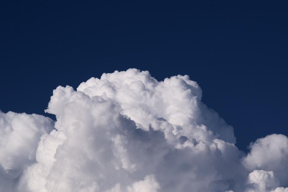 Free Image of Thick fluffy white clouds against a blue sky 