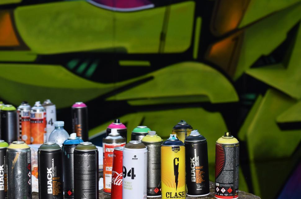 Free Image of Graffiti spray cans in front of art 