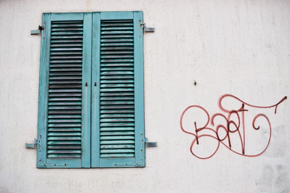 Free Image of Shuttered window with graffiti script 