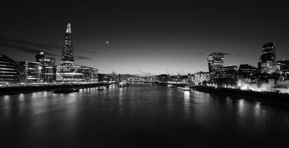 Free Image of Monochrome city skyline along the river at night 