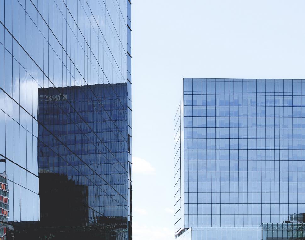 Free Image of Modern glass buildings reflecting blue skies 