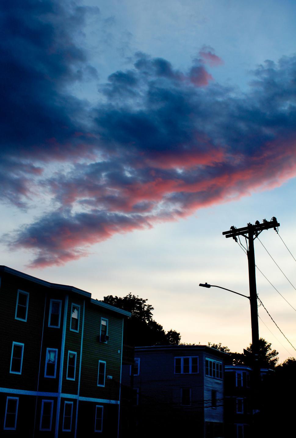 Free Image of Dramatic sunset clouds over colored houses 