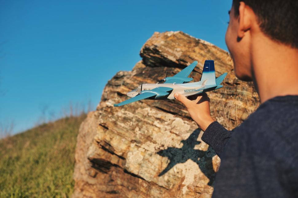Free Image of Person holding model airplane outdoors 