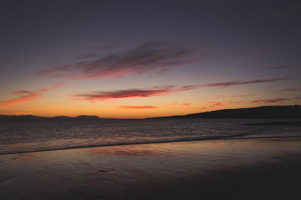 Free Image of Stunning sunset over tranquil beachscape 
