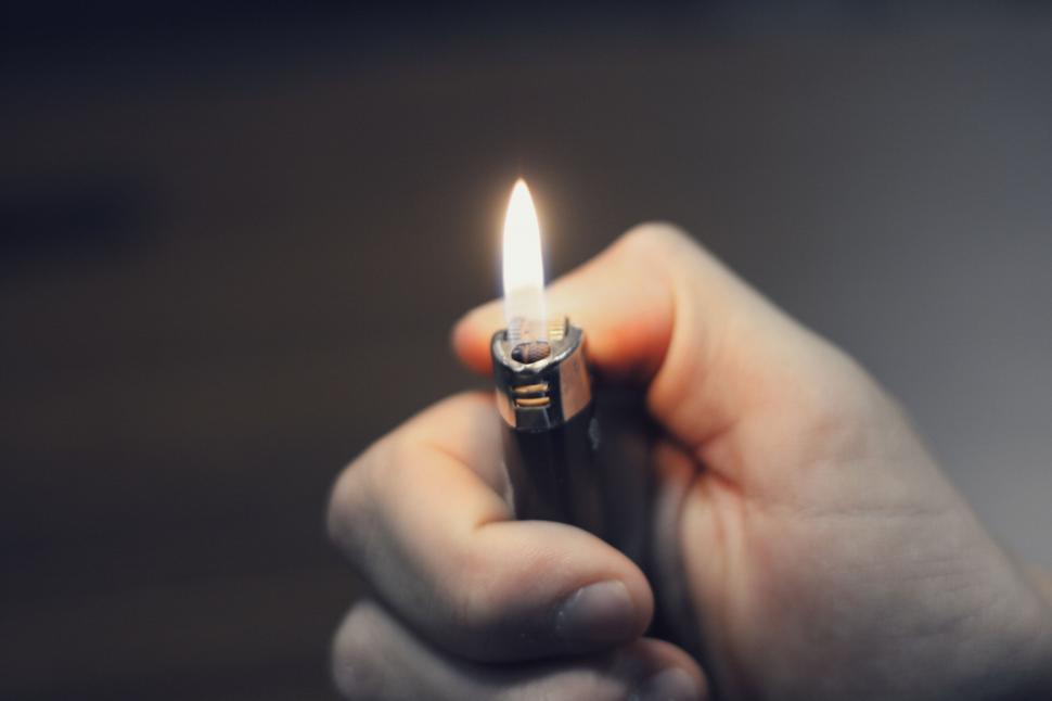 Free Image of Close-up of a lit lighter in hand 