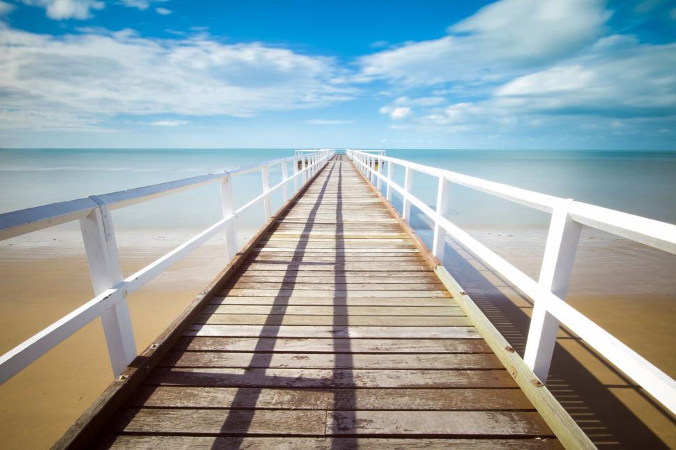 Free Image of Wooden pier stretching into calm sea 