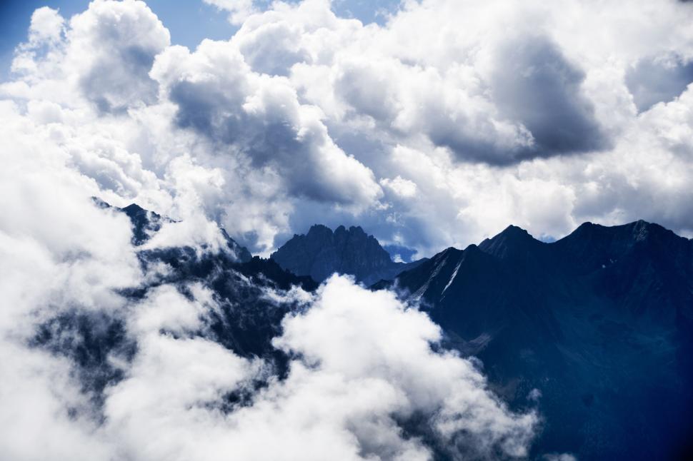 Free Image of Majestic cloudscape over rugged mountain peaks 
