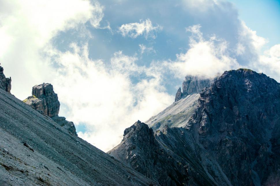 Free Image of Rocky peaks reaching into cloudy sky 