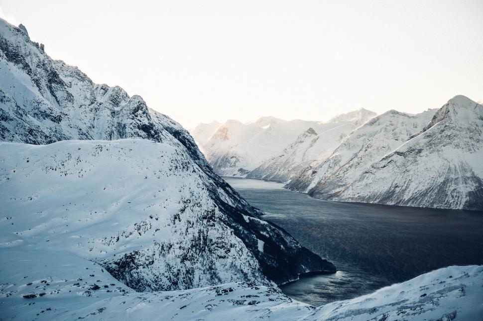 Free Image of Snow-covered mountains beside a tranquil fjord 
