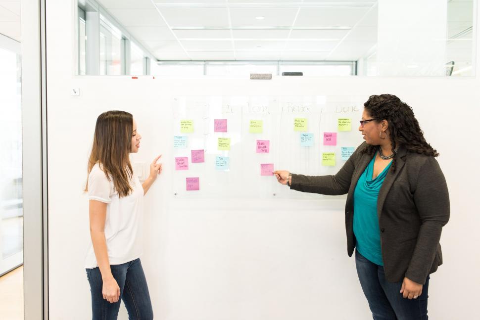 Free Image of Two professionals discussing over sticky notes 