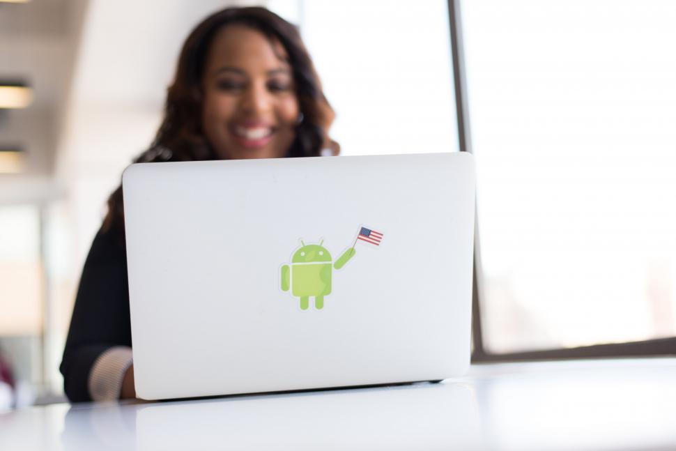 Free Image of Smiling woman with laptop showing stickers 
