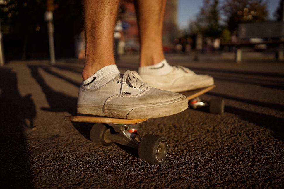 Free Image of Skateboarder cruising down city street 