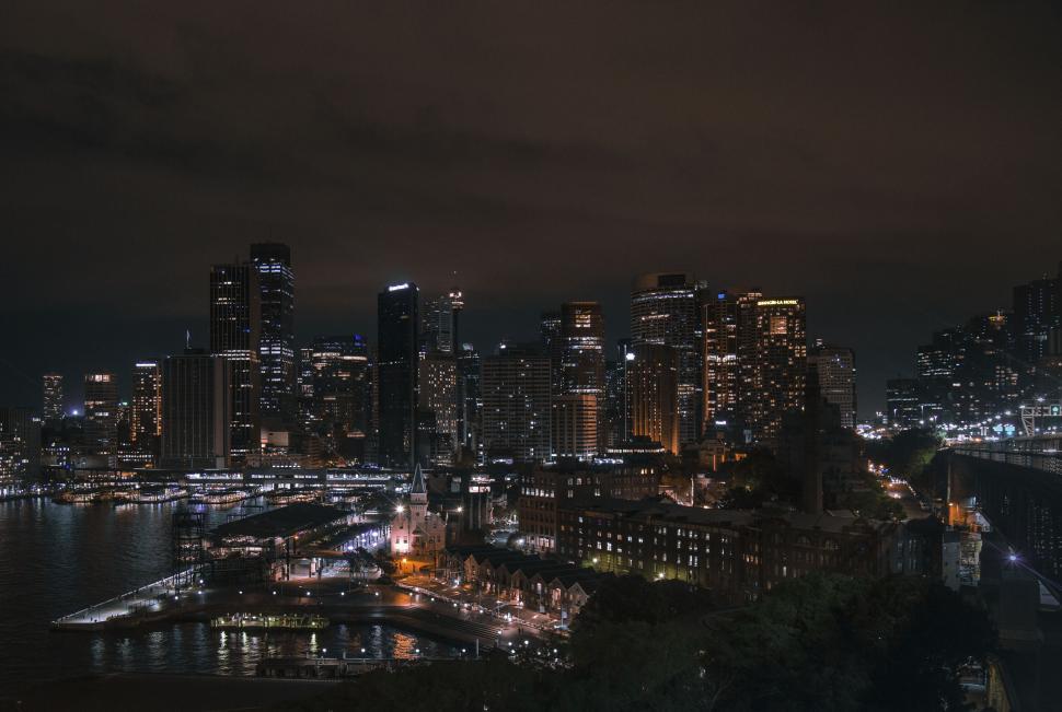 Free Image of Sydney skyline at night with lights reflecting 