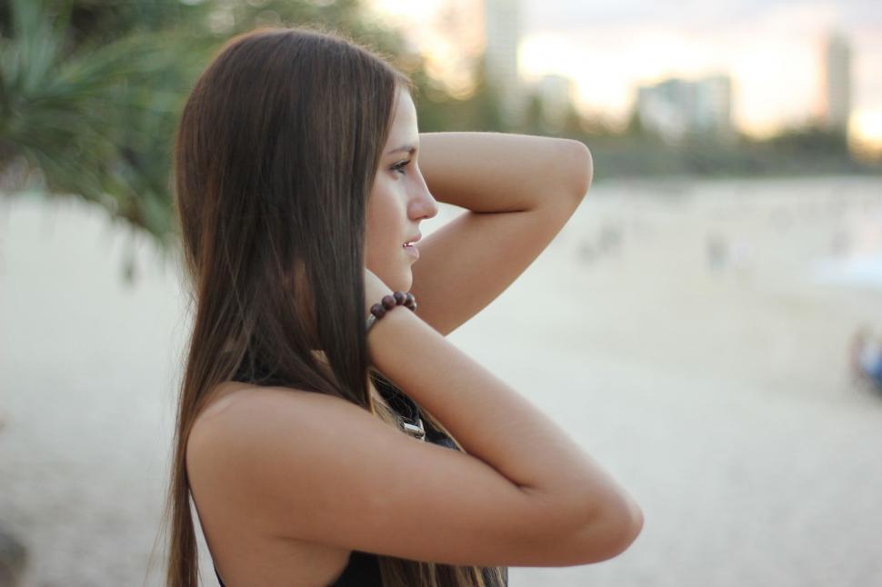 Free Image of Beach scene with woman touching her hair 
