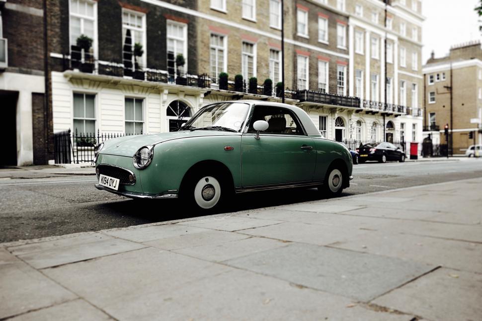 Free Image of Vintage green car parked on street 