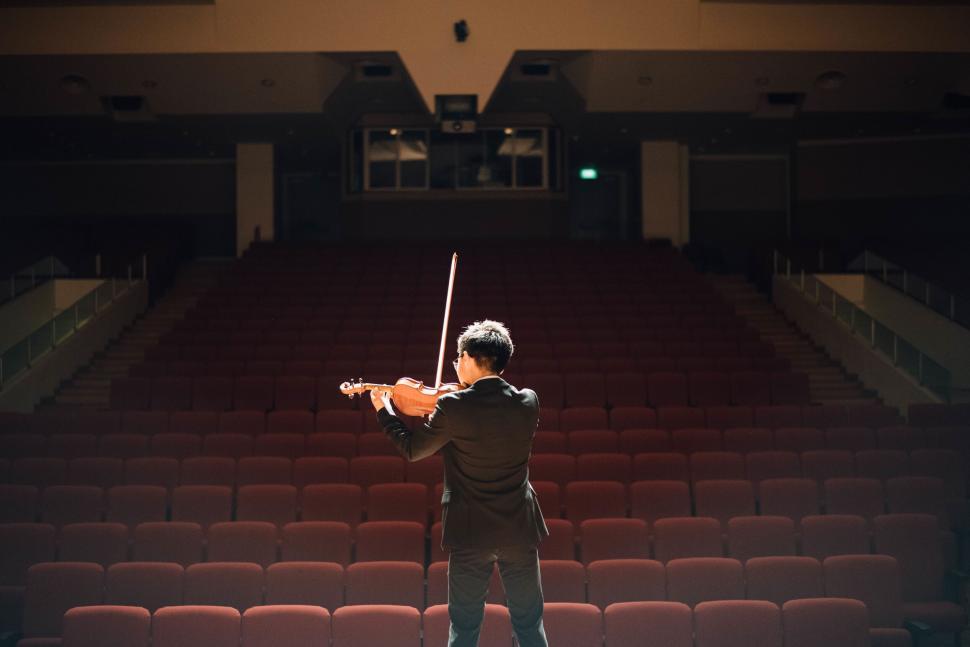 Free Image of Violinist practicing in an empty auditorium 