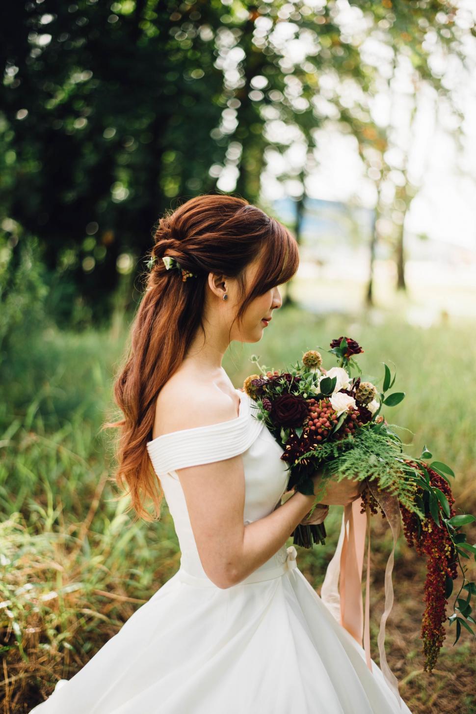 Free Image of Bride holding bouquet with obscured face 
