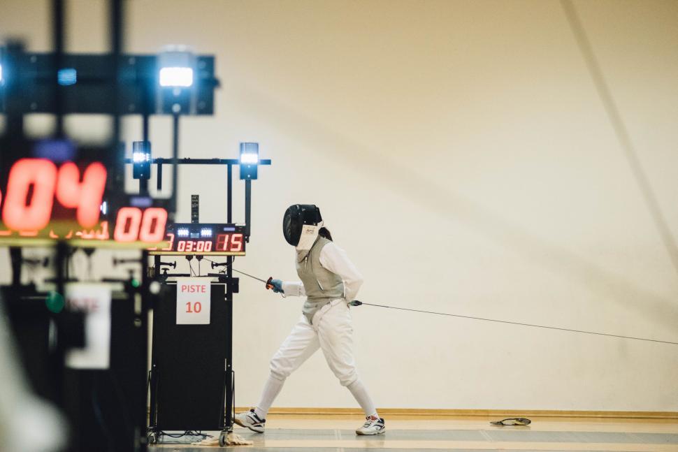 Free Image of Fencing athlete in competition with score display 