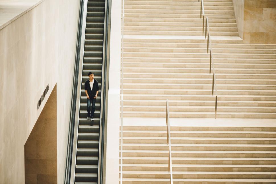 Free Image of Solitary figure on escalator against stairs 