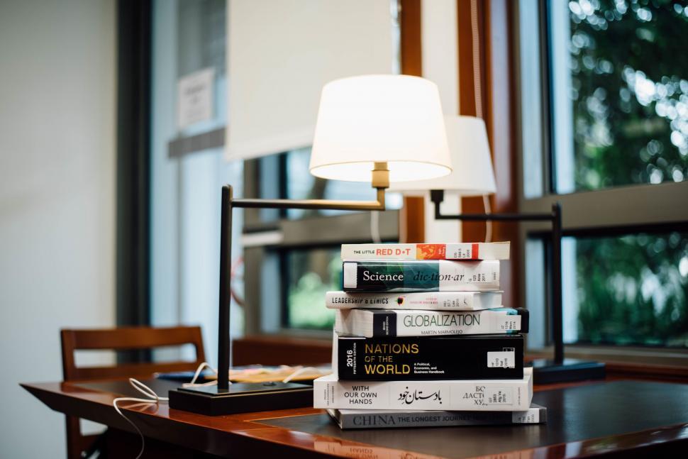 Free Image of Cozy study area with lamp and stacked books 