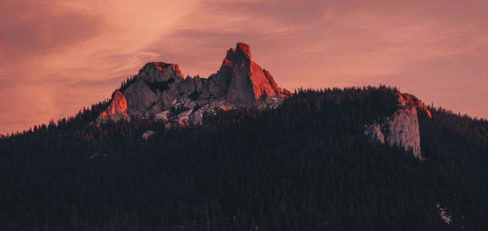 Free Image of Majestic sunset over a rugged mountain peak 