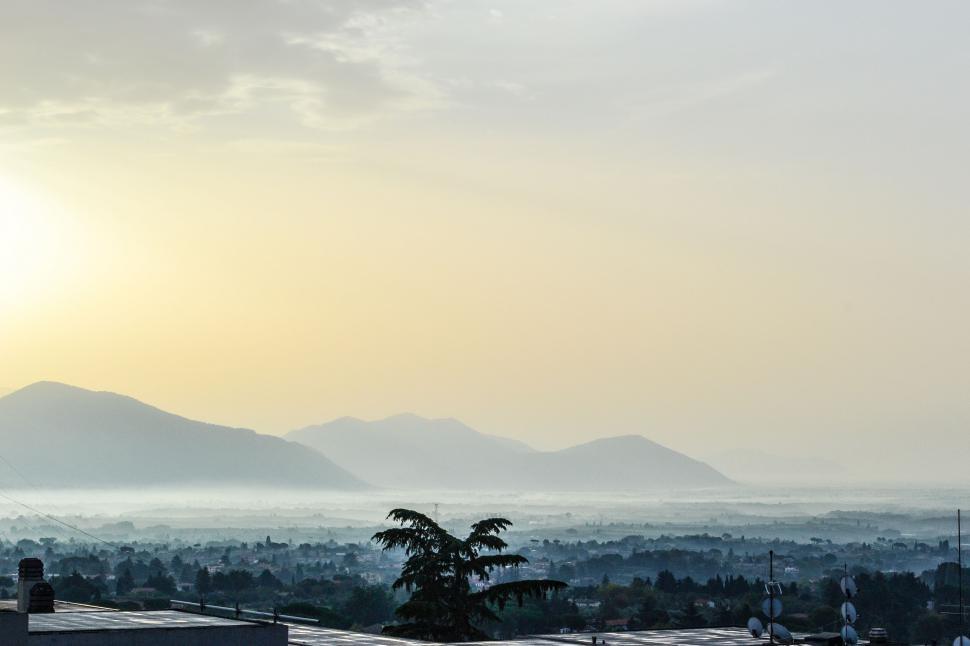 Free Image of Misty sunrise view over a hazy mountain valley 