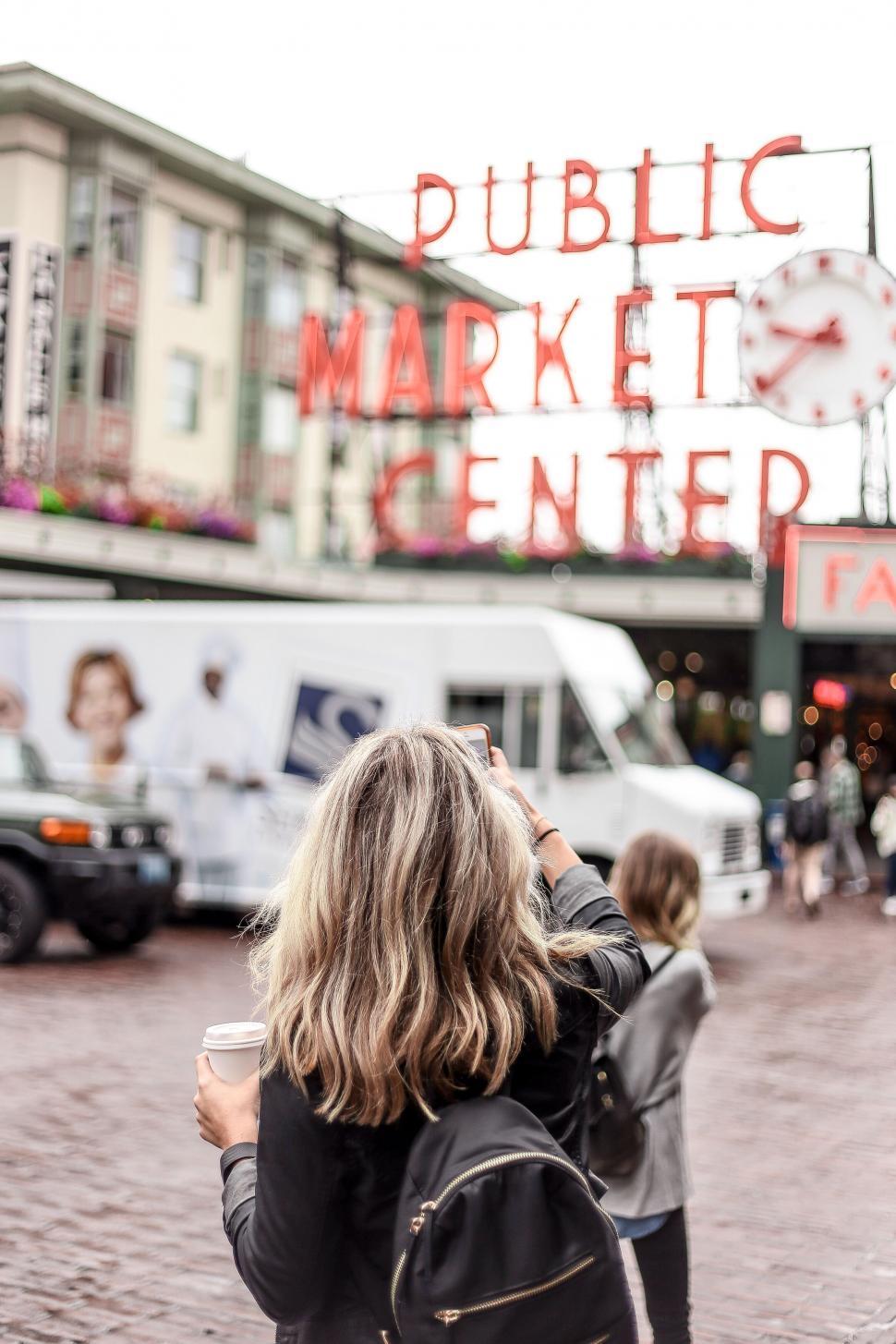 Free Image of Woman capturing market s sign with smartphone 