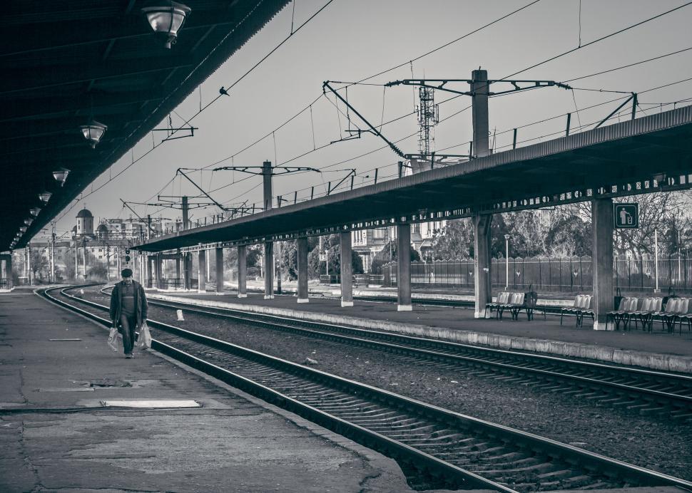 Free Image of Lone person walking on empty train platform 
