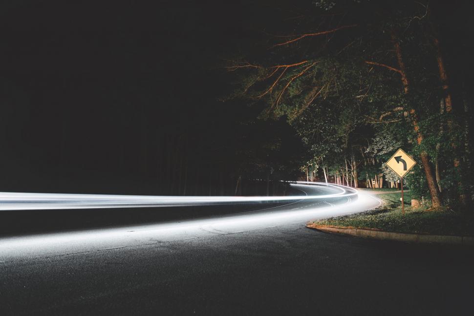 Free Image of Curved road with light trail at night 