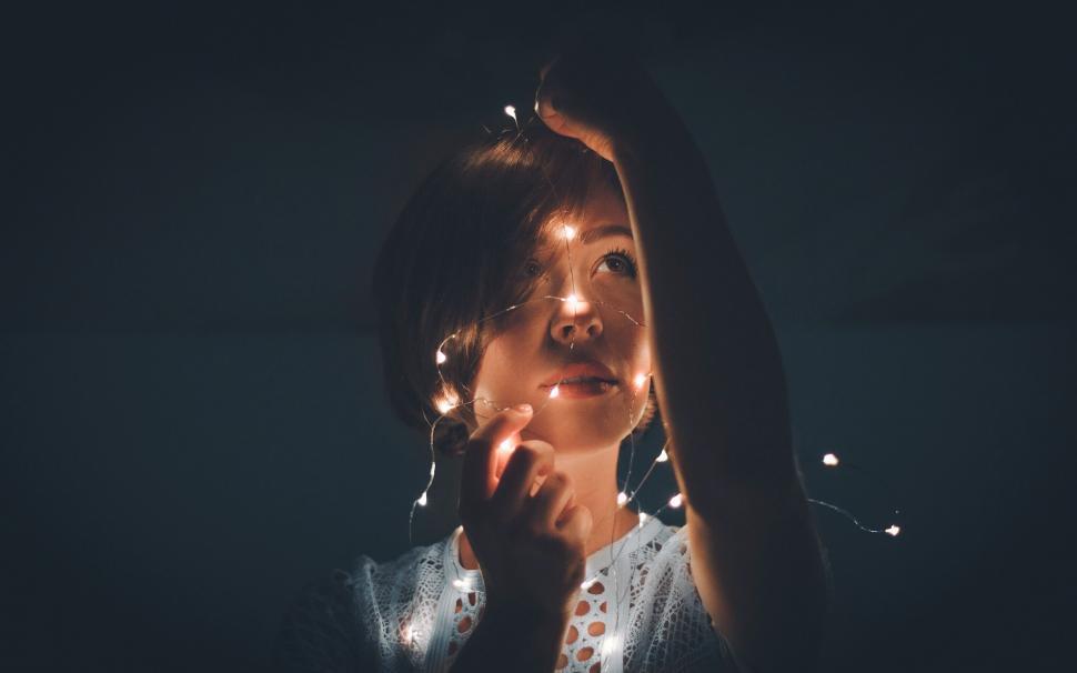 Free Image of Person with fairy lights obscuring face 