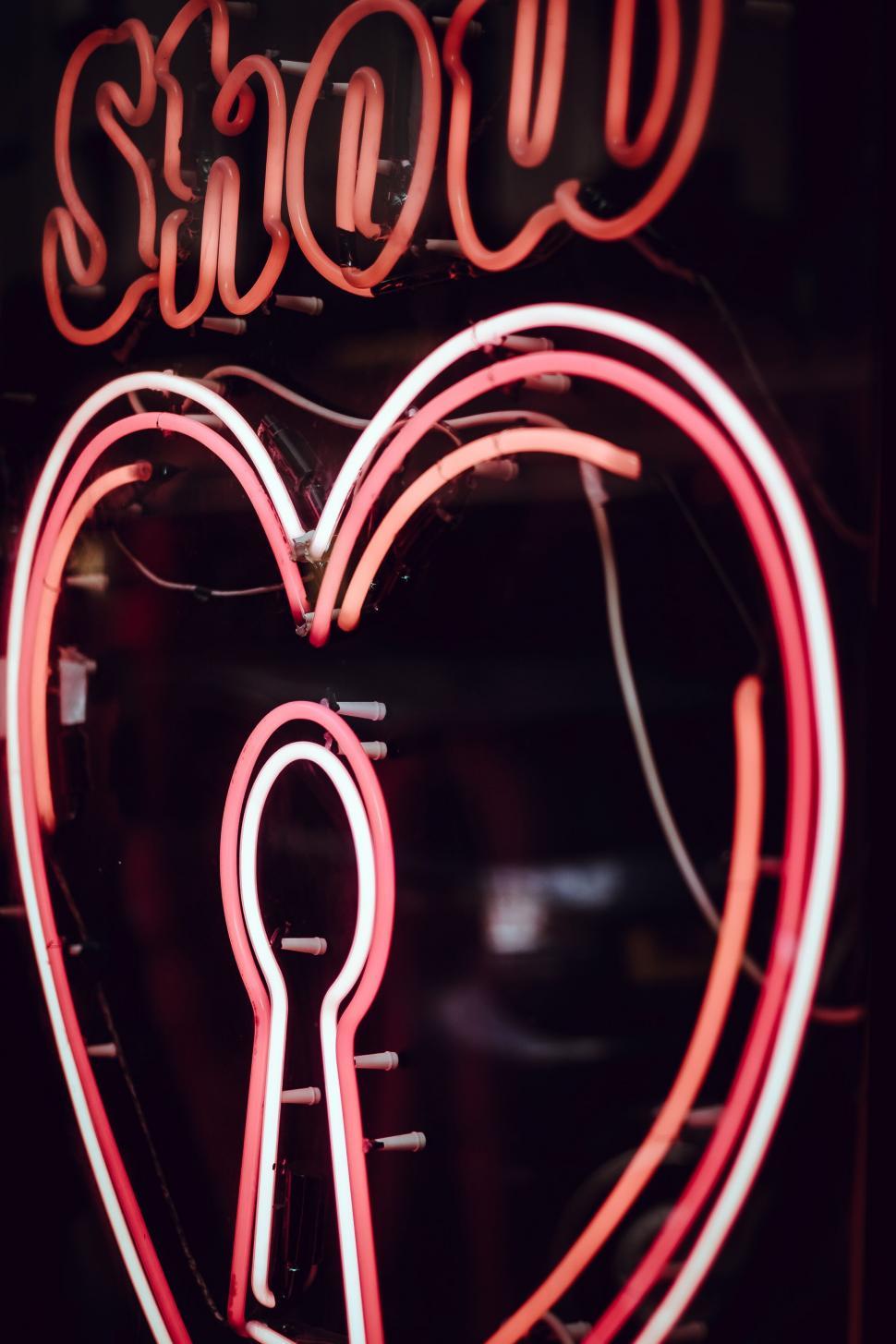 Free Image of Neon heart sign in a dim shop window 