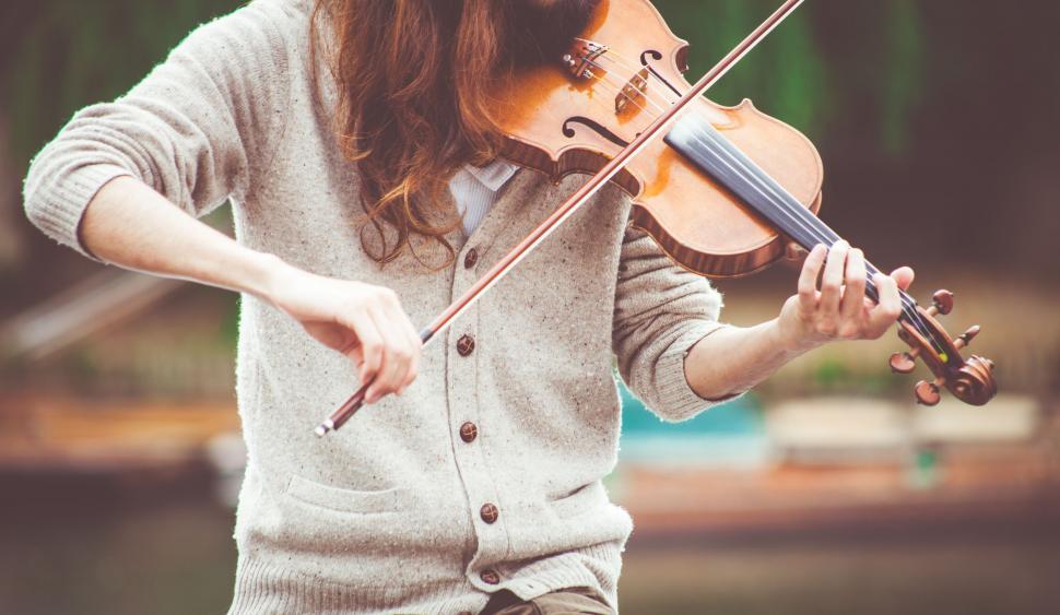 Free Image of Young woman playing violin in nature 