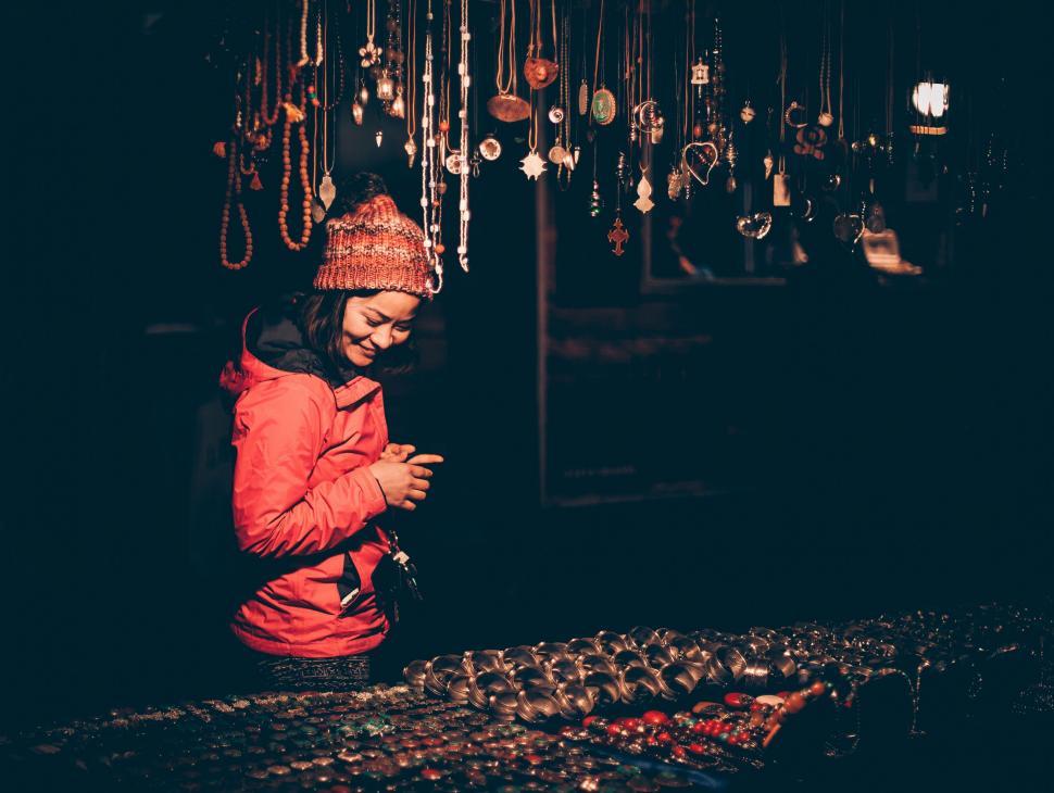 Free Image of Woman browsing jewelry at a night market 