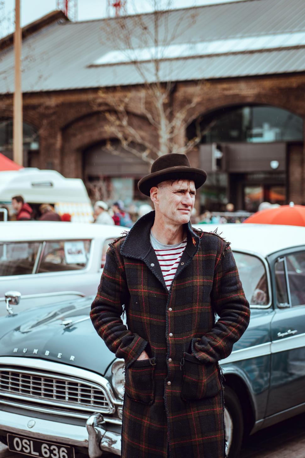Free Image of Stylish man by vintage car and market 