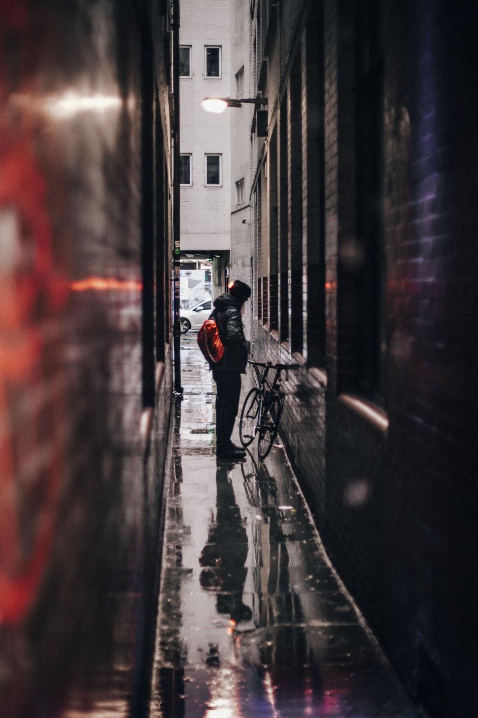 Free Image of Lonely figure in rainy alley 