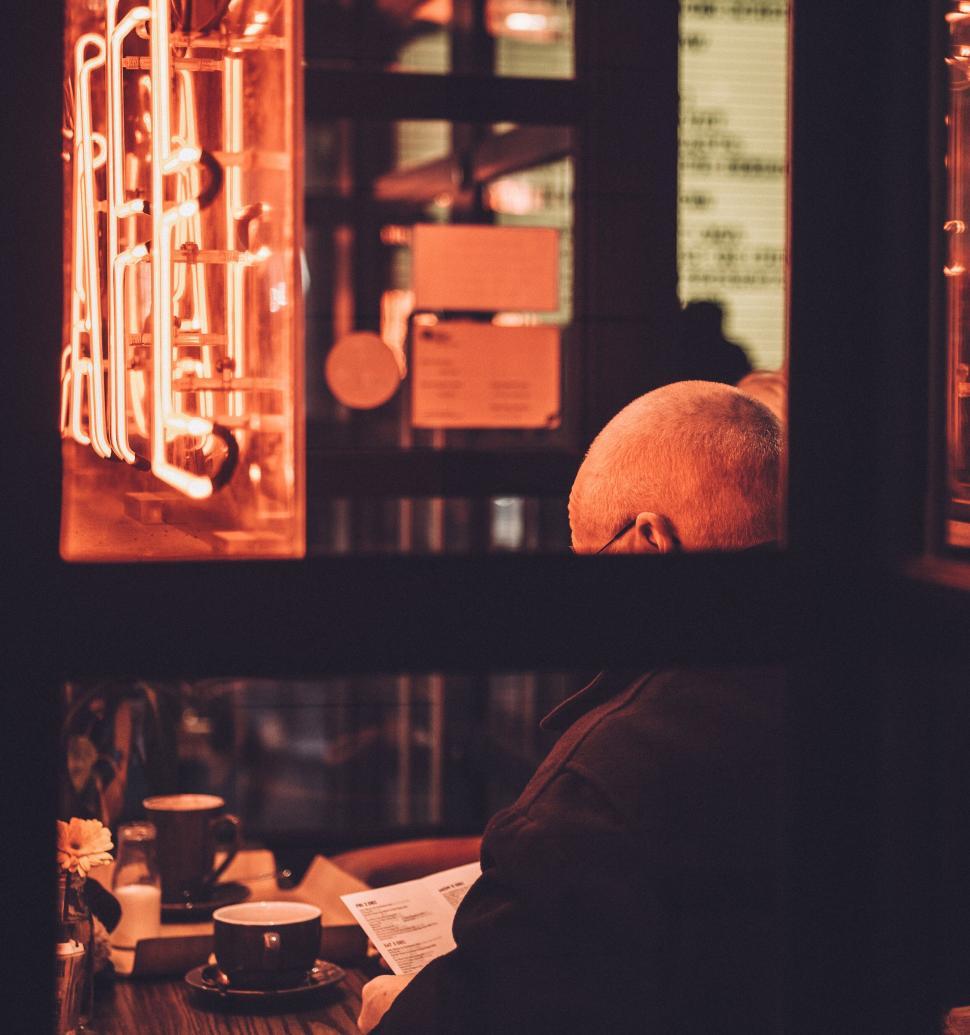 Free Image of Senior man reading menu by neon light 