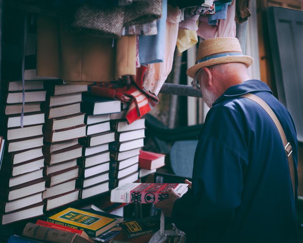 Free Image of Senior man browsing books at outdoor sale 