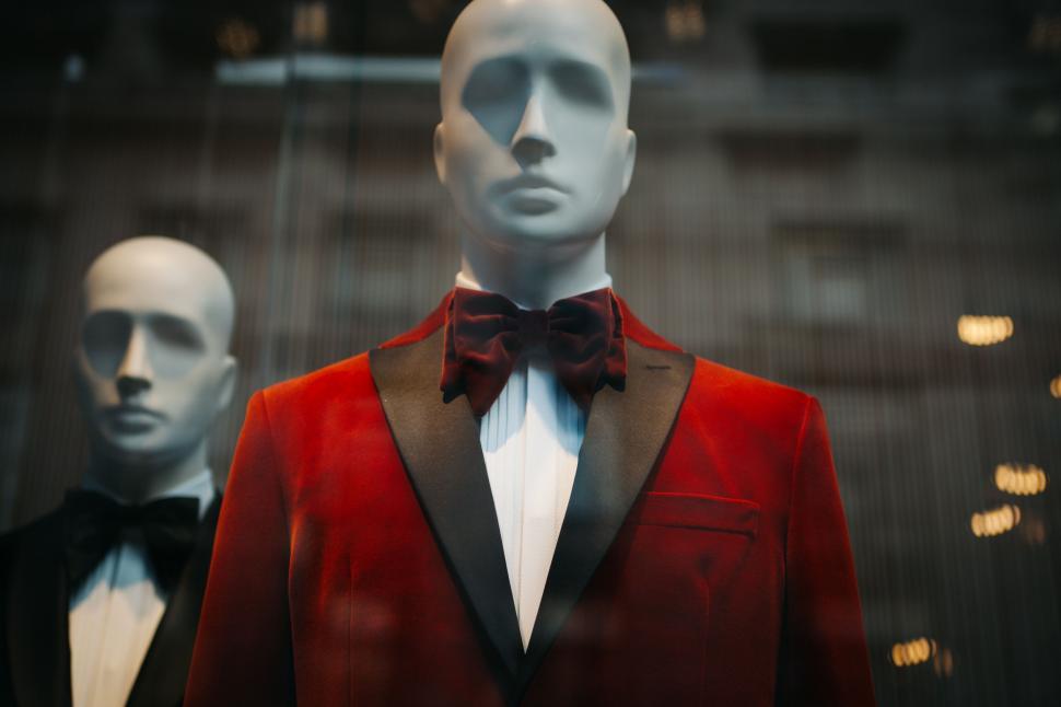 Free Image of Mannequins in red suits behind glass 