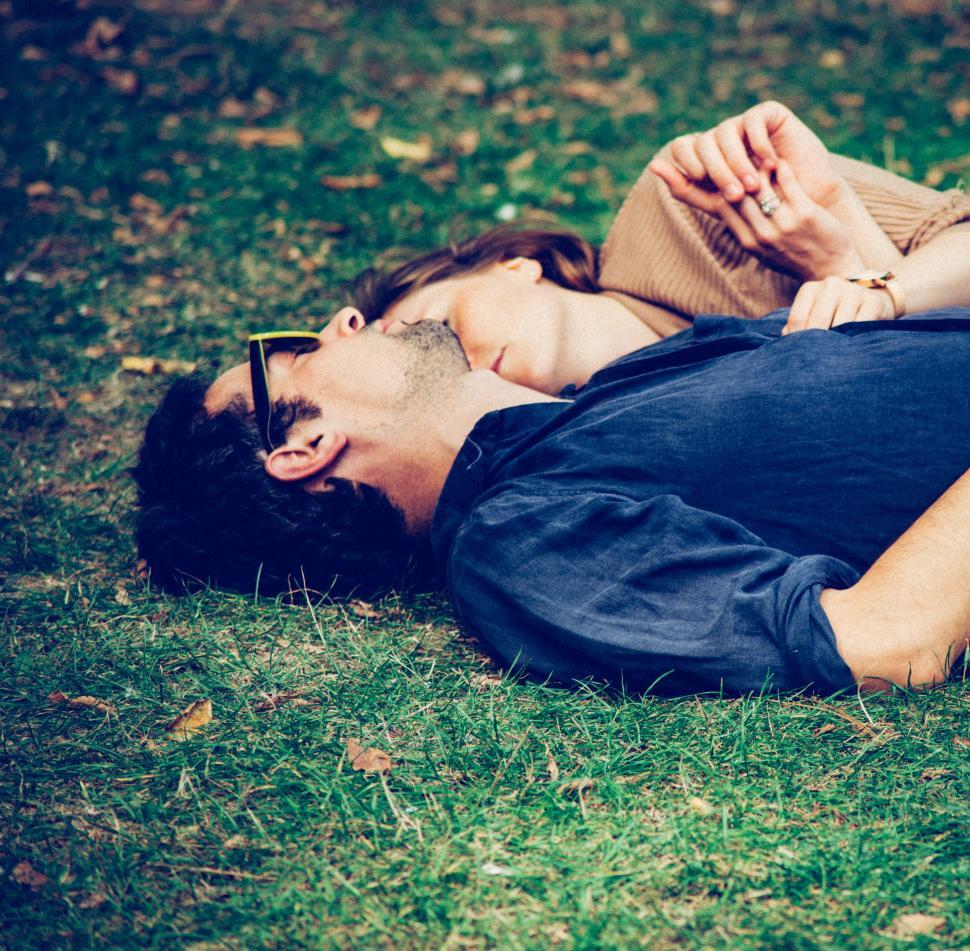 Free Image of Couple lying on grass in an embrace 