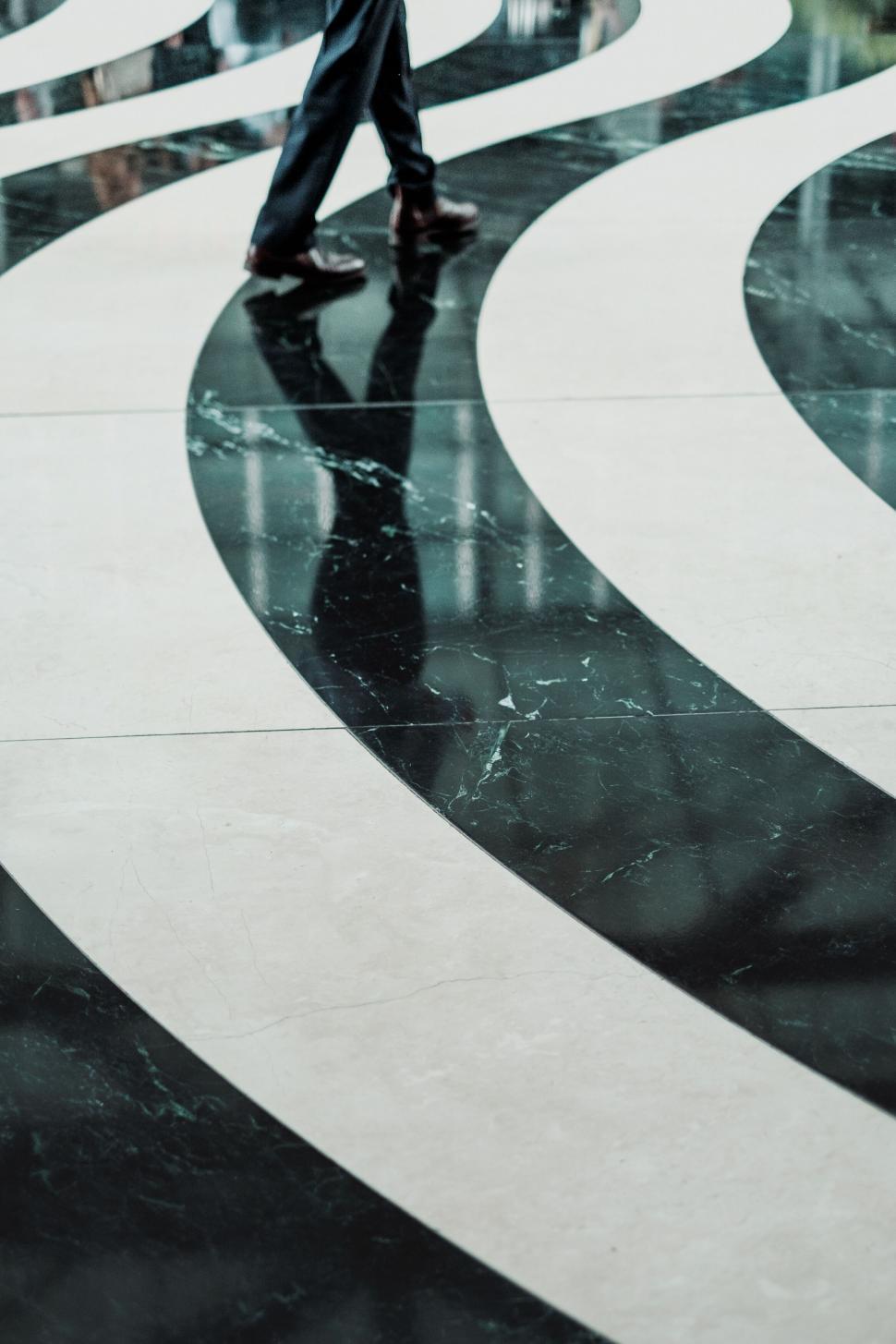 Free Image of Person walking on a black and white path 