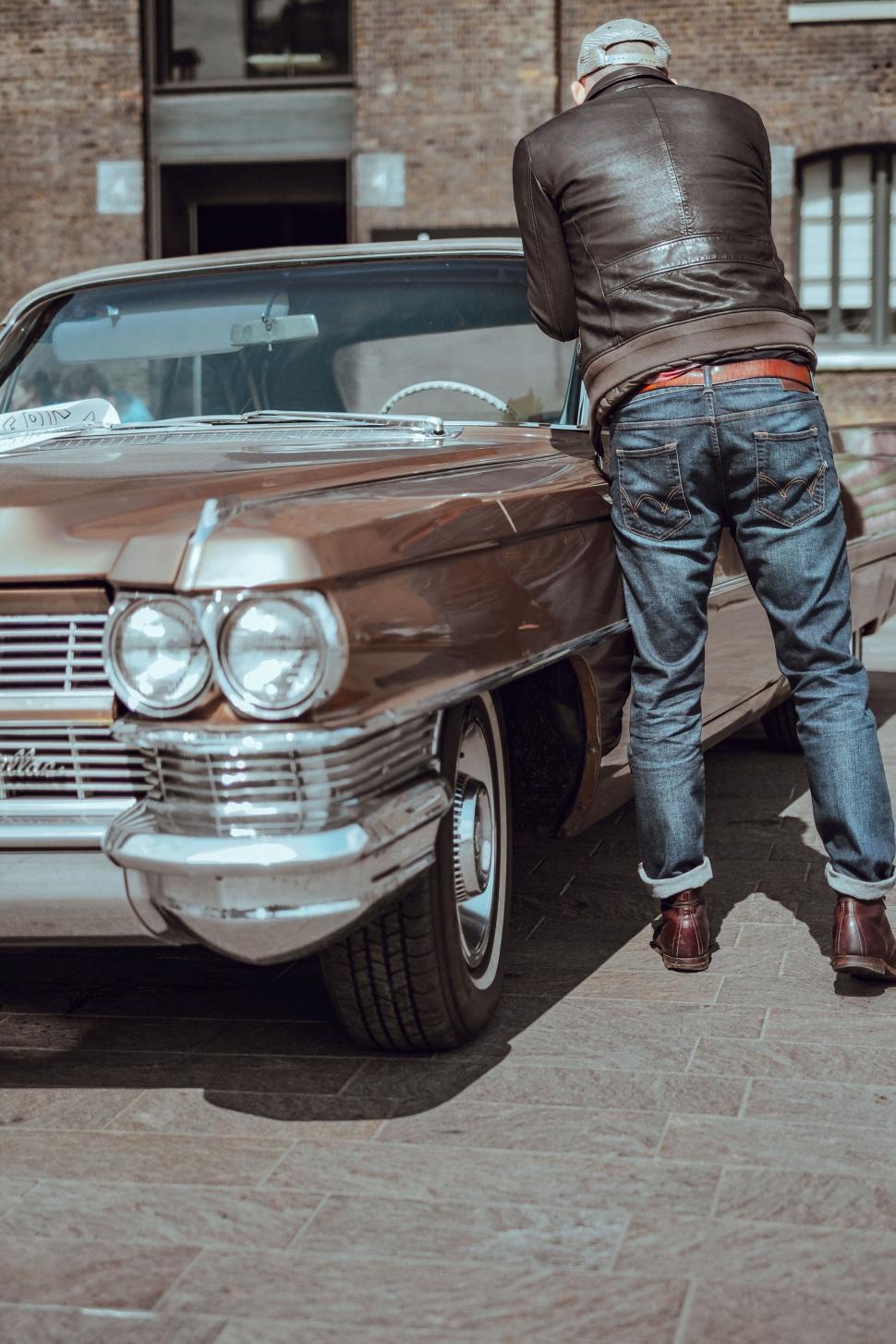 Free Image of Man inspecting a classic 1960 s car 
