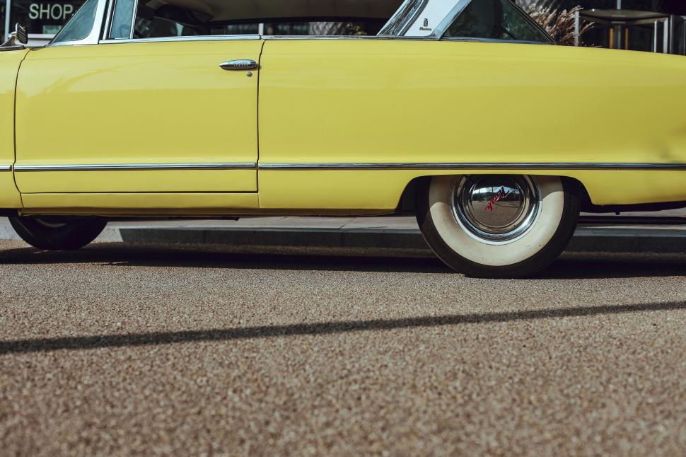 Free Image of Yellow vintage car parked on the street 